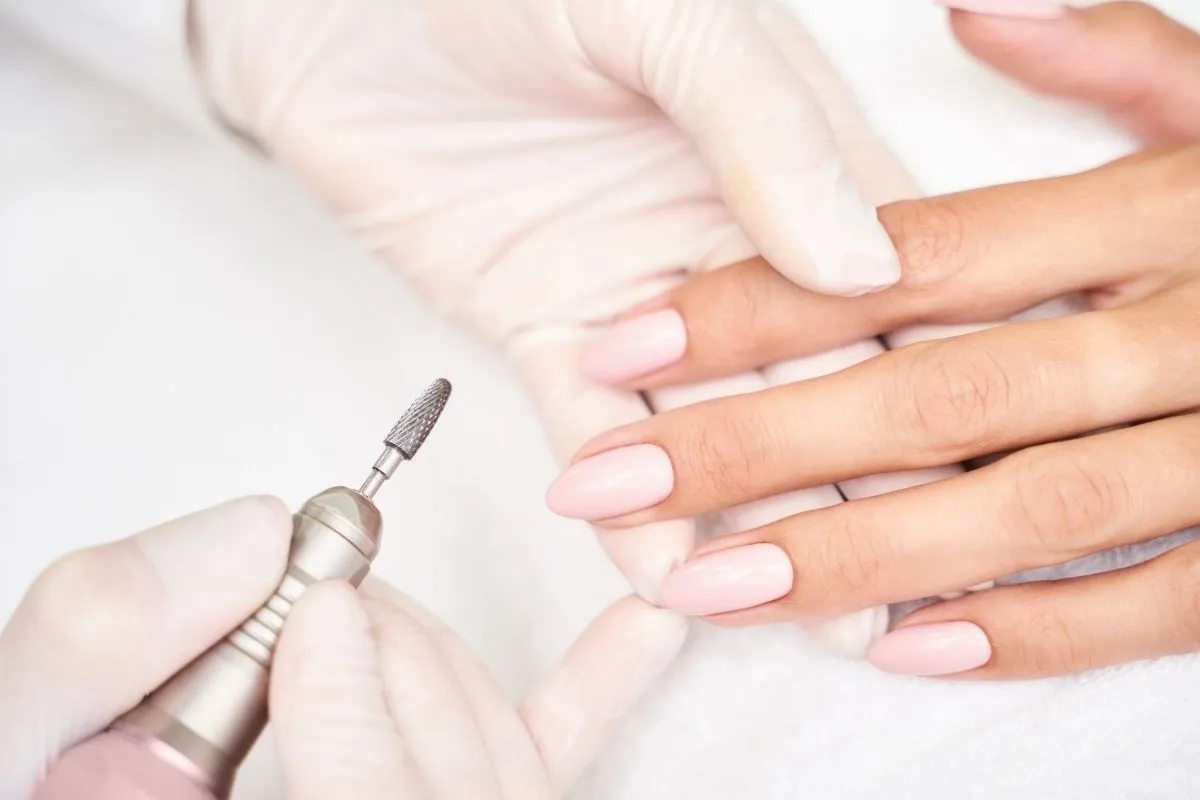 Prothésiste ongulaire réalisant une manucure dans un salon